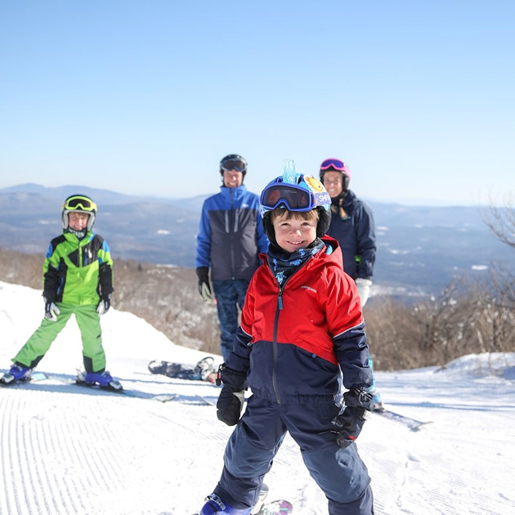 family of skiers posing and smiling